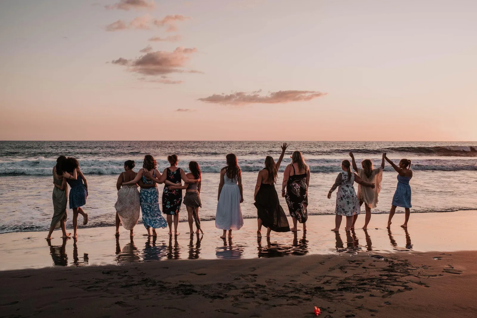 Women gathered at the shoreline at sunset